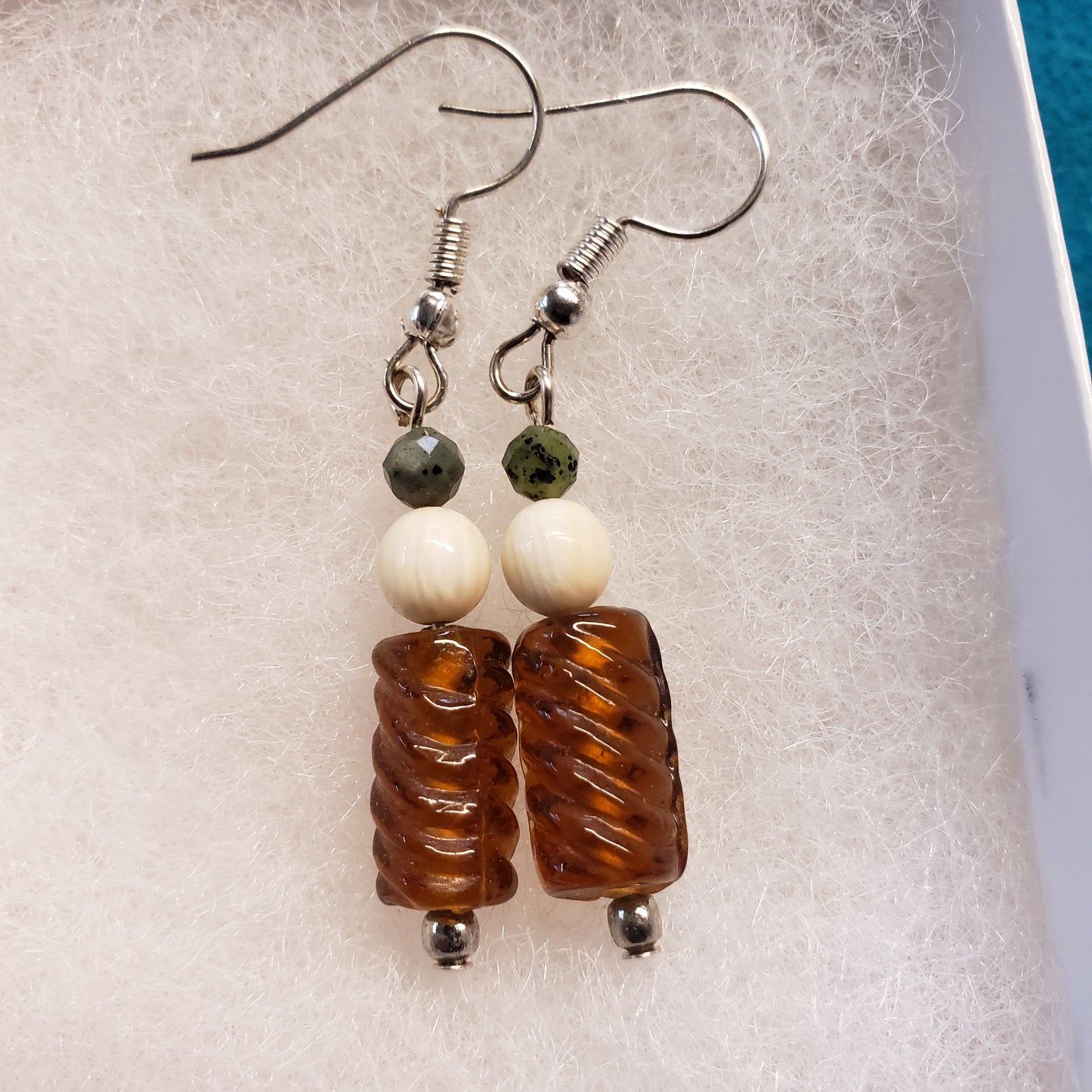 These 1" long antique gold toned glass bead earrings have been highlighted with 10,000 year old Alaskan Fossil Mammoth Ivory Beads and Canadian Jade Beads.
Hung on Hypoallergenic stainless steel earrings.