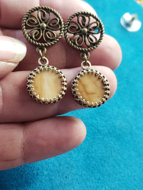 This pair of Rare Yellow Fossil Mammoth Ivory earrings is approximately 15,000 years of age. The Mammoth Ivory that this pair is made from was found is Siberia. They are colored just the way the Ivory was found and naturally stained by the Iron ore in the soil.  These are hung on bronze bezel settings. They are about 1.5